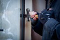 Burglar with crowbar to break door to enter the house Royalty Free Stock Photo