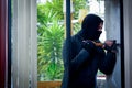 Burglar with crowbar trying break the window to enter the house Royalty Free Stock Photo