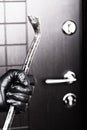 Burglar hand holding crowbar break opening door Royalty Free Stock Photo