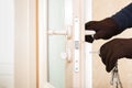 Burglar with lock picking tools breaking and entering into a house. Royalty Free Stock Photo