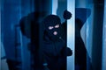 Burglar peeking into the house through an open glass door Royalty Free Stock Photo