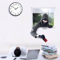 Burglar stealing credit card in office Royalty Free Stock Photo