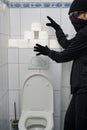 Burglar stealing Toilet paper in bathroom