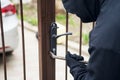 Burglar trying to break the gate with a crowbar. Burglar trying to force a lock using a crowbar Royalty Free Stock Photo