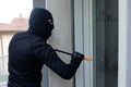 Burglar trying to force a door lock using crowbar Royalty Free Stock Photo