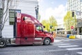 Burgundy big rig powerful semi truck tractor without of semi trailer running on the urban city street with traffic light and Royalty Free Stock Photo