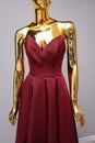 Burgundy fashion long dress on gold mannequin
