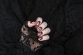 Burgundy golg cracle matte nail polish. Manicured nail with dark matte nail polish isolated on black Royalty Free Stock Photo