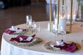 Burgundy napkins lie on white plates on a solemn day