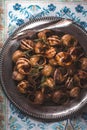 Burgundy snails with herbs on the napkin pattern background top view