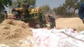 Indian farmers separating husk and wheat grain by use of thresher machine Royalty Free Stock Photo