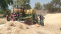 Indian farmers separating husk and wheat grain by use of thresher machine Royalty Free Stock Photo