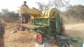 Landscape view of farmers using thresher machine