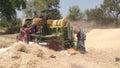 Landscape view of farmers using thresher machine