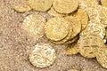Buried Pirate Treasure Gold Coins in the Sand on a Sandy Beach