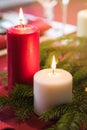 Buring red and white Christmas candles with fir-tree branch Royalty Free Stock Photo