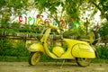 An antique yellow Vespa scooter parked