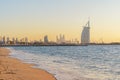 Burj Al Arab in Jumeirah Island or boat building with waves on sea beach, Dubai Downtown skyline, United Arab Emirates or UAE.