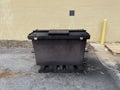 Locked Solid waste trash compactor front distant view