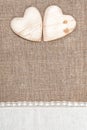 Burlap background with lacy cloth and wooden hearts Royalty Free Stock Photo