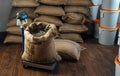 Burlap bag with coffee beans and a metal scoop stands on a weighing scale Royalty Free Stock Photo