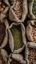 burlap bags overflowing with a diverse array of beans, including black, red, yellow long-legged, green round-shaped