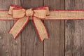 Burlap Christmas bow and ribbon top border on wood Royalty Free Stock Photo