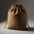 A burlap drawstring bag with a textured surface is set against a neutral background. Royalty Free Stock Photo