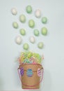 Easter basket spills eggs on green pastel background