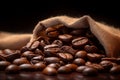 Burlap sack of coffee beans against dark wood background with whole coffee beans spilling out over wood panel Royalty Free Stock Photo