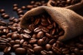 Burlap sack of coffee beans against dark wood background with whole coffee beans spilling out over wood panel Royalty Free Stock Photo