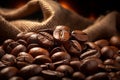 Burlap sack of coffee beans against dark wood background with whole coffee beans spilling out over wood panel Royalty Free Stock Photo