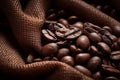 Burlap sack of coffee beans against dark wood background with whole coffee beans spilling out over wood panel Royalty Free Stock Photo