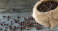 A burlap sack filled with coffee beans and many spilled out in front. Royalty Free Stock Photo