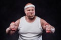 A very fat man in a white T-shirt with two dumbbells in each hand Royalty Free Stock Photo