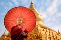 Burmese Buddhist monk walk with umbella in Shwezigon Paya golden pagoda Royalty Free Stock Photo