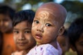 Burmese child with traditional Thanaka face paint poses for portrait