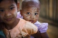 Burmese child with traditional Thanaka face paint poses for portrait