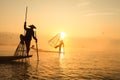 Burmese fisherman on bamboo boat catching fish in traditional wa Royalty Free Stock Photo