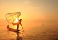 Burmese fisherman on bamboo boat catching fish in traditional wa Royalty Free Stock Photo