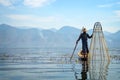 Burmese fisherman on bamboo boat catching fish in traditional way with handmade net. Inle lake, Myanmar Burma Royalty Free Stock Photo