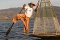 Burmese fisherman on bamboo boat catching fish in traditional way with handmade net. Inle lake, Myanmar, Burma Royalty Free Stock Photo