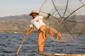 Burmese fisherman on bamboo boat catching fish in traditional way with handmade net. Inle lake, Myanmar, Burma Royalty Free Stock Photo