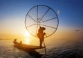 Burmese fisherman on bamboo boat catching fish in traditional way with handmade net. Inle lake, Myanmar Burma travel destination Royalty Free Stock Photo