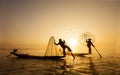 Burmese fisherman on bamboo boat catching fish in traditional wa Royalty Free Stock Photo