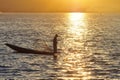 Burmese fisherman on boat catching fish in traditional way in Inle lake, Myanmar