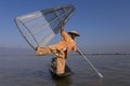 Burmese fisherman posing with foot holding his cone shaped fishing net, Inle Lake, Shan State, Myanmar