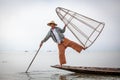 Burmese fisherman posing for tourists in a traditional fishing boat at Inle Lake, Myanmar Royalty Free Stock Photo