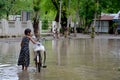 Burmese girl riding bicycle in flood area