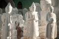 Burmese man carving a large marble Buddha statue.